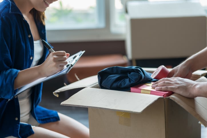 young couple packing and checking stuff using a checklist before moving to a new residence