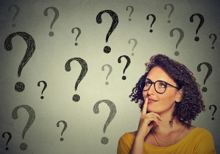 A woman think about how to better organize her day surrounded by question marks