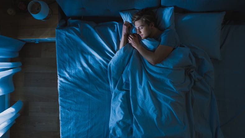 Top View of Handsome Young Man Sleeping Cozily on a Bed in ...