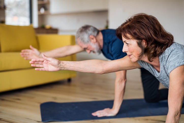 senior couple exercising in their home