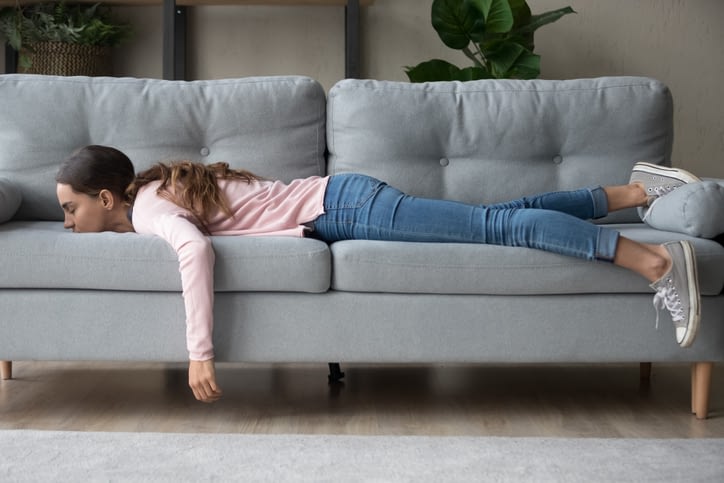 girl stretched out on a couch feeling overwhelmed